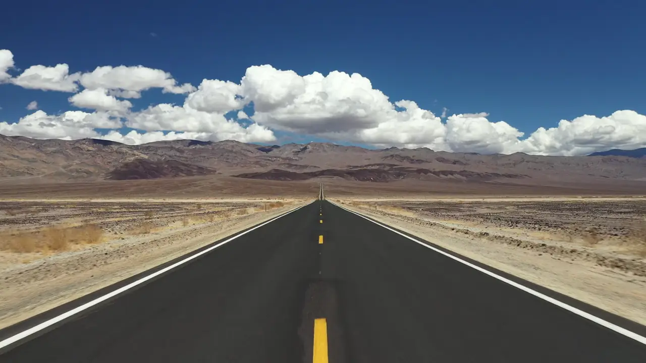 Carretera recta que cruza el desierto, vista desde un coche en marcha